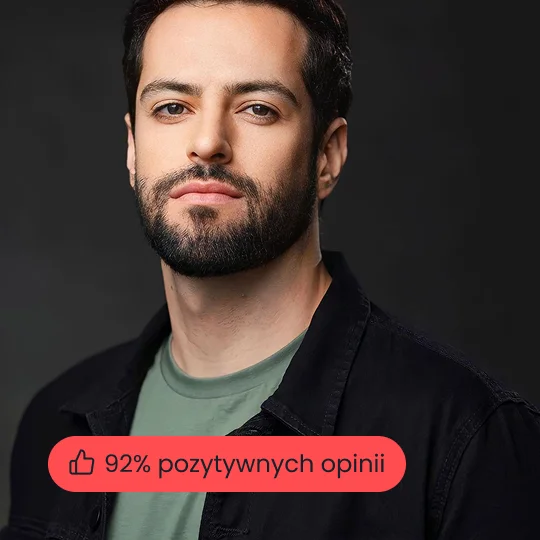 Formalne zdjęcie portretowe uśmiechniętego biznesmena w granatowej marynarce i koszuli na czarnym tle studyjnym.