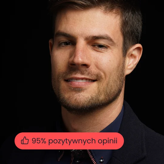 Zdjęcie studyjne pewnego siebie mężczyzny z brodą, ubranego w zieloną koszulkę i czarną marynarkę, na ciemnym, neutralnym tle.
