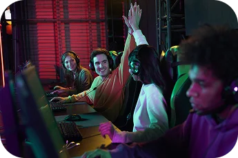 Drużyna e-sportowa świętuje zwycięstwo podczas wydarzenia LAN, podnosząc ręce w górę, nosząc słuchawki w neonowo oświetlonej arenie do gier.